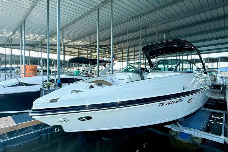 Slide: The Image of 2011 Rinker 276 Captiva boat docked in a covered marina. - 15