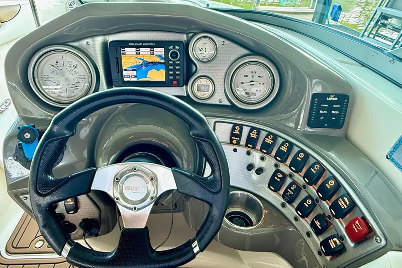 Slide: The Image of 2011 Rinker 276 Captiva boat dashboard with steering wheel and navigation controls. - 27