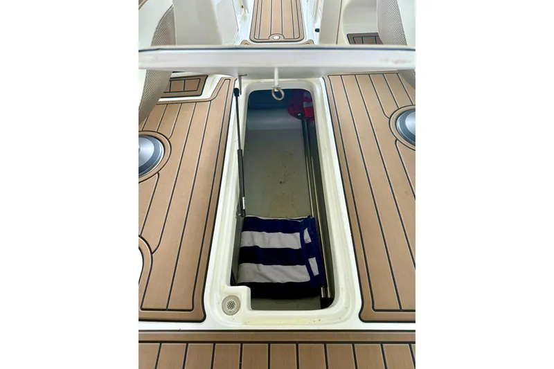 Slide: The Image of 2011 Rinker 276 Captiva boat storage compartment with striped towel inside. - 31