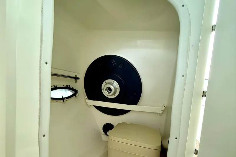 Slide: The Image of 2011 Rinker 276 Captiva boat interior with compact toilet and porthole window. - 32