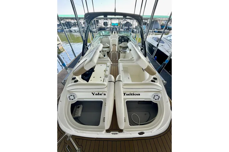 Slide: The Image of 2011 Rinker 276 Captiva boat interior with seating and storage compartments at a marina. - 33