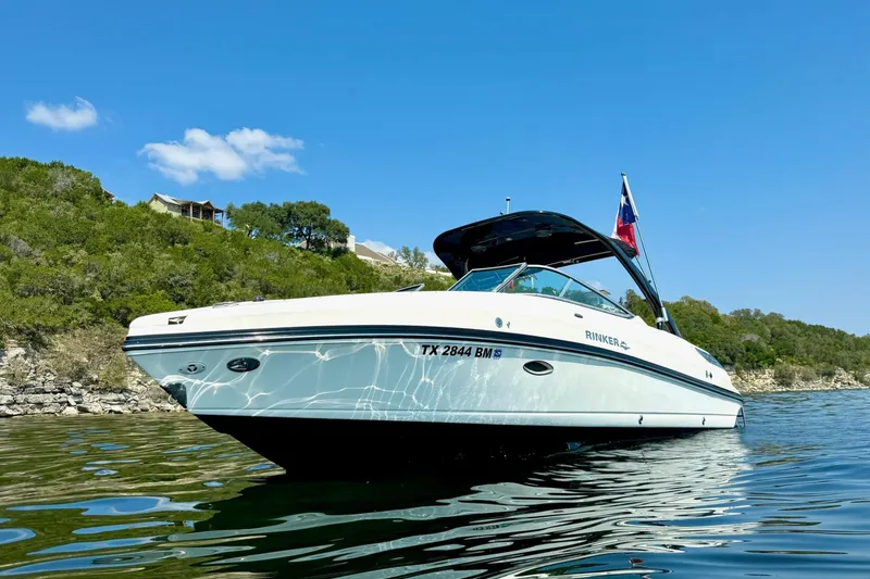 Slide: The Image of 2011 Rinker 276 Captiva boat on a sunny lake with scenic background. - 4