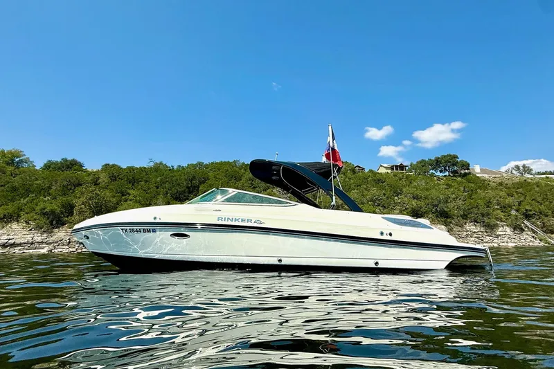 Slide: The Image of 2011 Rinker 276 Captiva boat on a lake with clear blue sky. - 5