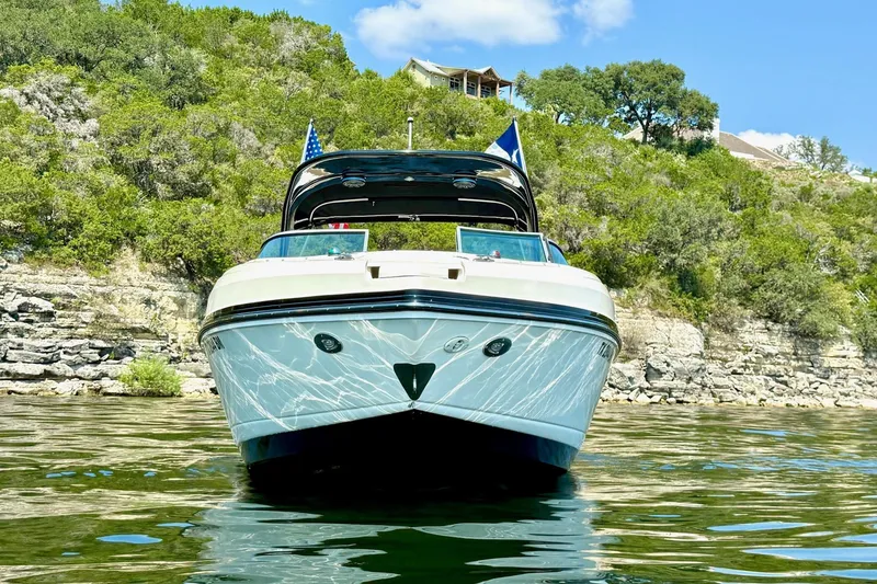 Slide: The Image of 2011 Rinker 276 Captiva boat on a scenic lake with rocky shoreline. - 7