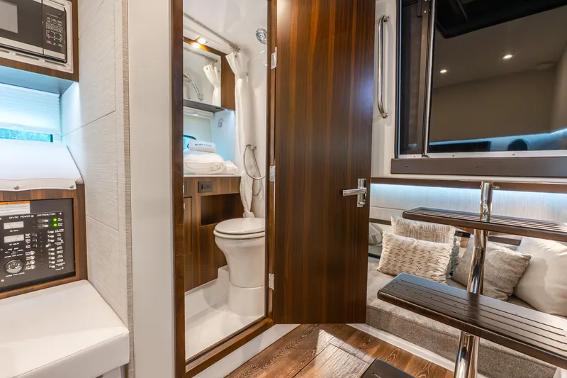 Slide: The Image of 2024 Cruisers Yachts 34 GLS OB interior with modern bathroom and cozy seating area. - 12