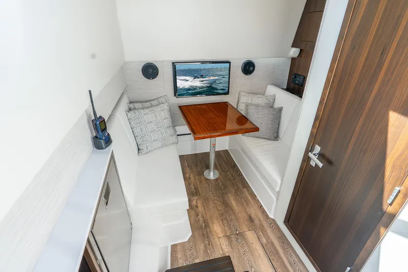 Slide: The Image of 2024 Cruisers Yachts 34 GLS OB cabin with seating, table, and modern decor. - 16