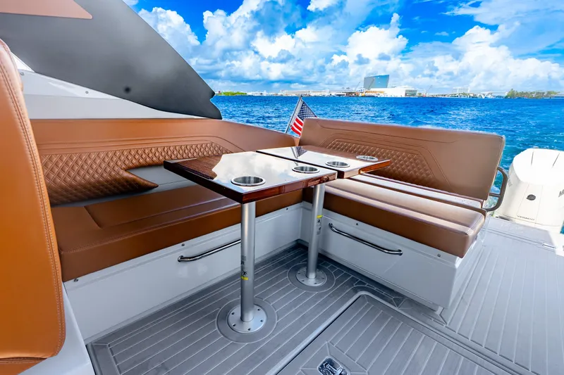 Slide: The Image of 2024 Cruisers Yachts 34 GLS OB interior with brown seating, table, and ocean view. - 19