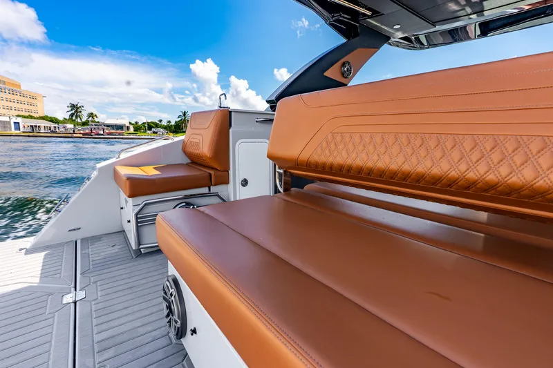 Slide: The Image of 2024 Cruisers Yachts 34 GLS OB with luxurious tan seating, docked by the water. - 21