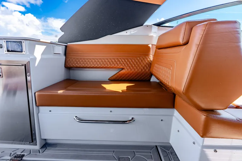 Slide: The Image of 2024 Cruisers Yachts 34 GLS OB interior with brown leather seating and stainless steel accents. - 24