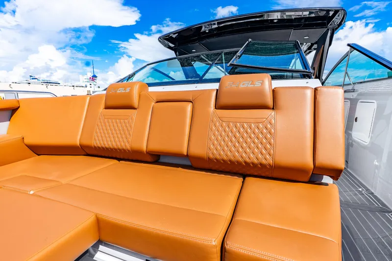 Slide: The Image of 2024 Cruisers Yachts 34 GLS OB with luxurious tan seating under a clear blue sky. - 26