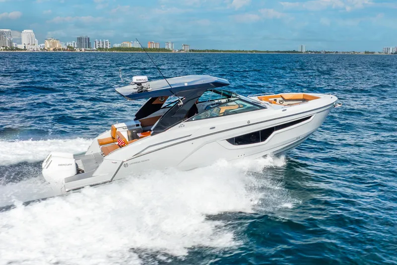 Slide: The Image of 2024 Cruisers Yachts 34 GLS OB speeding on ocean near city skyline. - 3