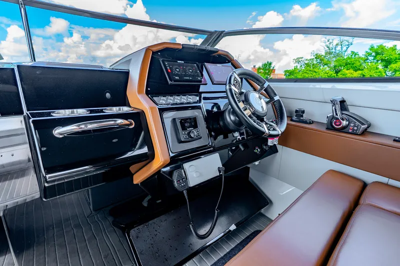 Slide: The Image of 2024 Cruisers Yachts 34 GLS OB helm with modern controls and leather seating. - 31