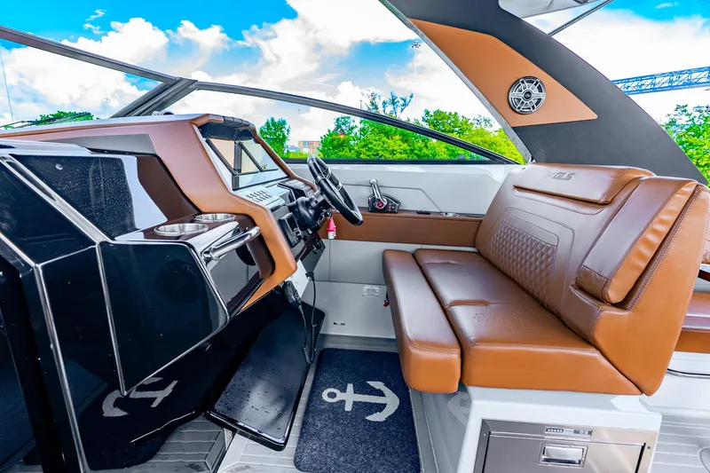 Slide: The Image of 2024 Cruisers Yachts 34 GLS OB interior with brown leather seating and modern dashboard. - 32