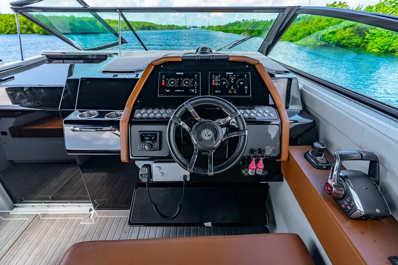 Slide: The Image of 2024 Cruisers Yachts 34 GLS OB helm with modern controls and scenic water view. - 33
