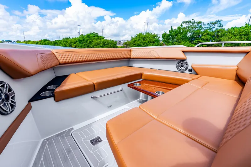 Slide: The Image of Luxurious seating area on 2024 Cruisers Yachts 34 GLS OB, featuring tan upholstery and cup holders. - 35