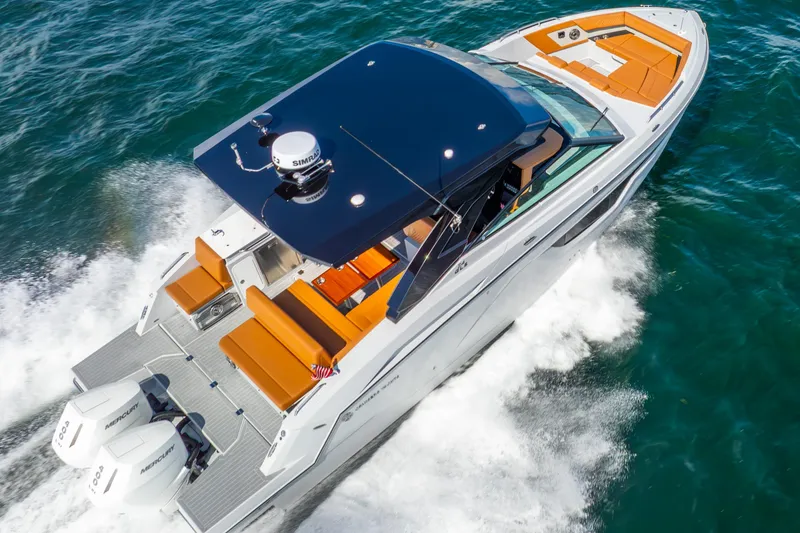 Slide: The Image of 2024 Cruisers Yachts 34 GLS OB cruising on open water, showcasing sleek design and powerful engines. - 4