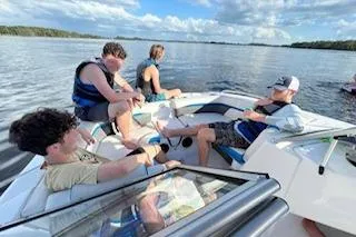 Slide: The Image of People relaxing on a 2020 Hurricane SunDeck 191 OB boat in a scenic lake. - 11