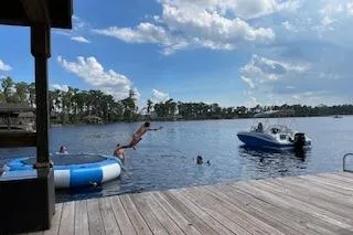 Slide: The Image of People enjoying a lake with a 2020 Hurricane SunDeck 191 OB boat nearby. - 12