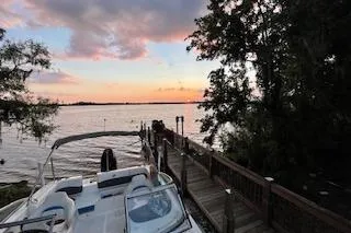 Slide: The Image of 2020 Hurricane SunDeck 191 OB boat docked at sunset by a serene lake. - 13