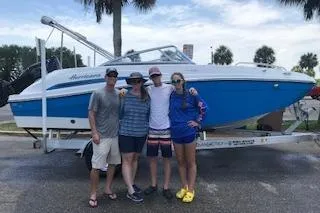 Slide: The Image of Group posing with 2020 Hurricane SunDeck 191 OB boat on trailer, palm trees in background. - 4
