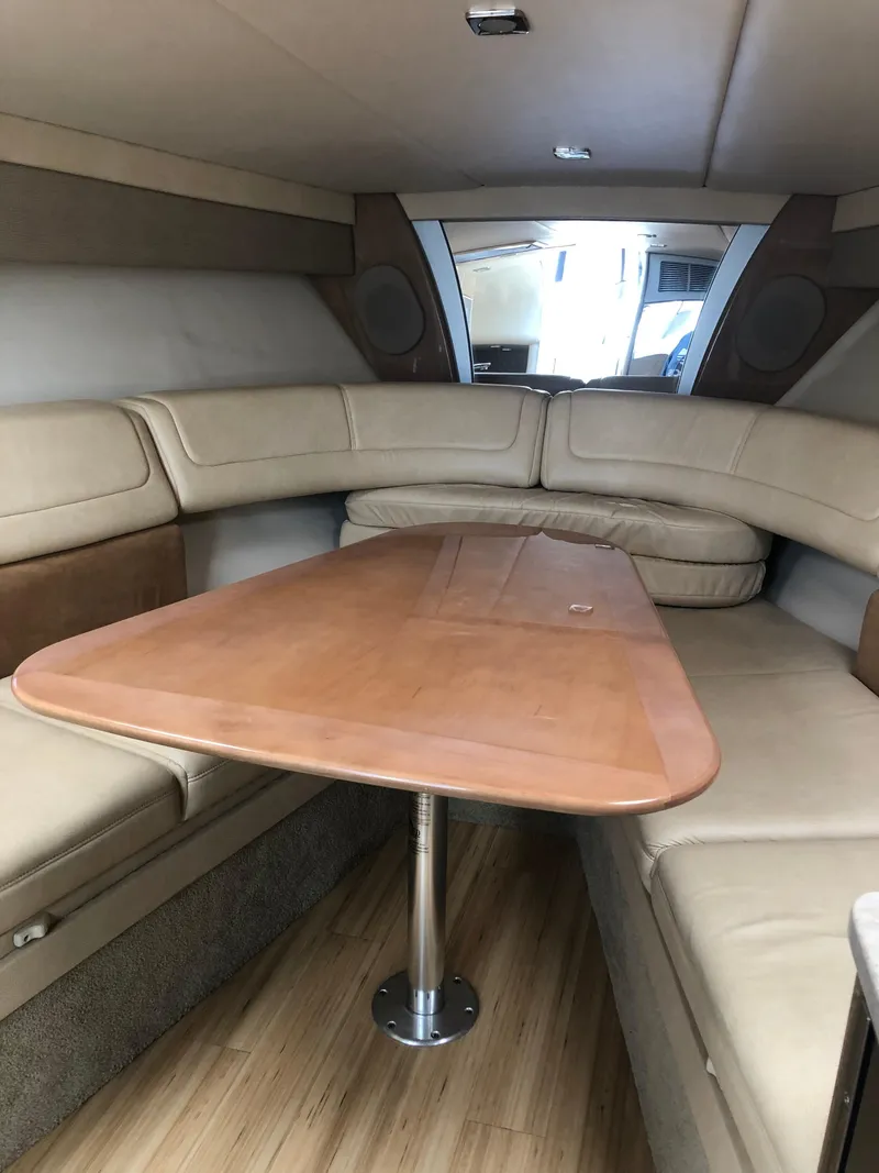Slide: The Image of 2013 Formula 350 Sun Sport cabin with beige seating and wooden table. - 16