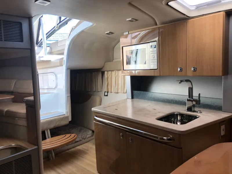 Slide: The Image of 2013 Formula 350 Sun Sport interior with kitchenette, microwave, and seating area. - 18