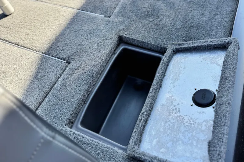 Slide: The Image of 2019 Tracker Pro Team 175 boat storage compartment with carpeted interior. - 16