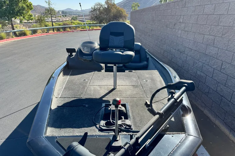 Slide: The Image of 2019 Tracker Pro Team 175 boat parked on pavement, featuring a fishing seat and trolling motor. - 7