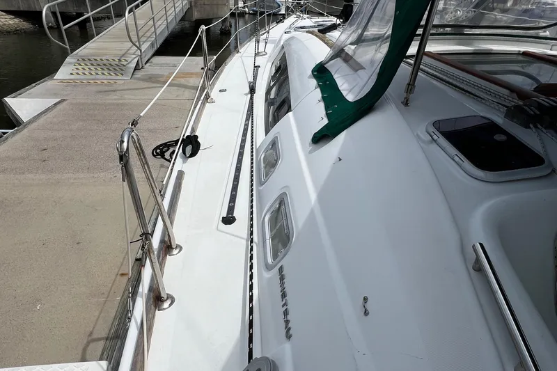 Slide: The Image of Beneteau Oceanis 46 sailboat docked, side view, showcasing deck and railings, 2007 model. - 17