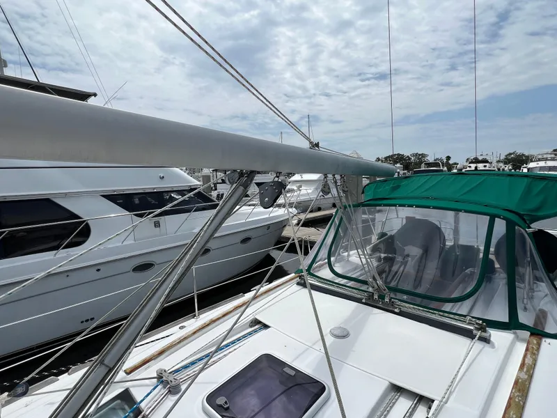 Slide: The Image of 2007 Beneteau Oceanis 46 sailboat docked, featuring green canopy and sleek design. - 27