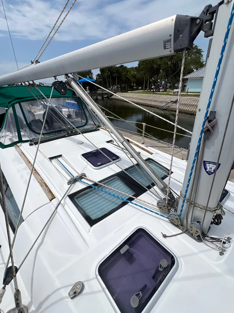 Slide: The Image of 2007 Beneteau Oceanis 46 sailboat deck with rigging and hatches, docked by a canal. - 31
