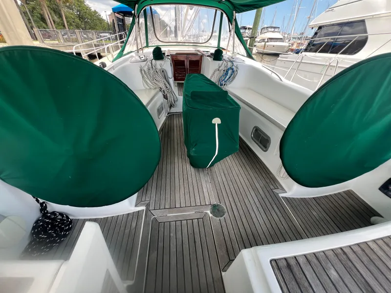 Slide: The Image of 2007 Beneteau Oceanis 46 yacht cockpit with green covers and wooden flooring. - 42