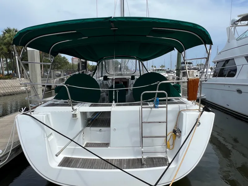 Slide: The Image of 2007 Beneteau Oceanis 46 sailboat docked, featuring green canopy and spacious deck. - 7