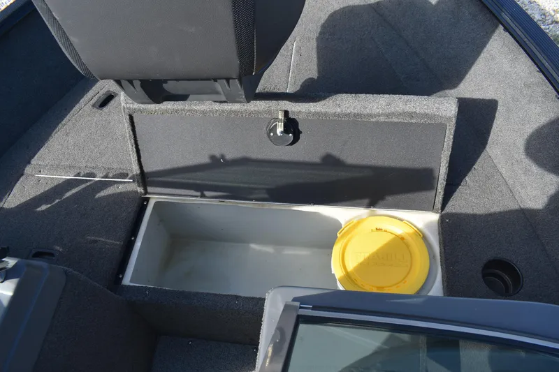 Slide: The Image of 2014 Lund 1650 Rebel XL Sport boat storage compartment with yellow lid container. - 16