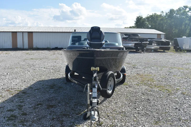 Slide: The Image of 2014 Lund 1650 Rebel XL Sport boat on trailer in gravel lot. - 2