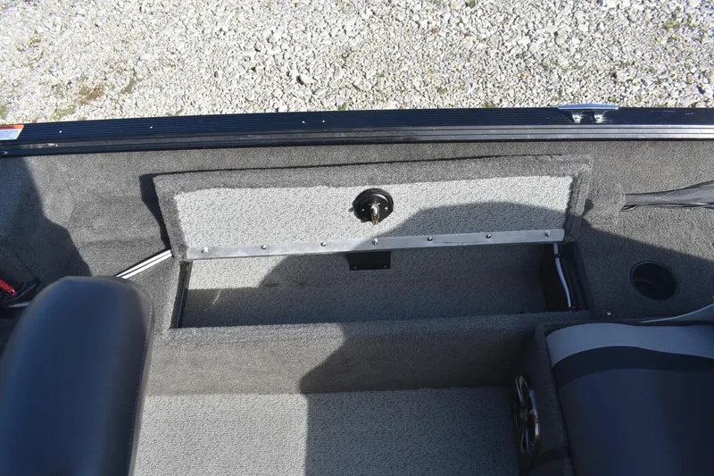 Slide: The Image of 2014 Lund 1650 Rebel XL Sport boat interior with storage compartment and seating. - 21