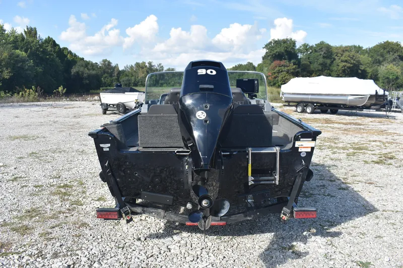 Slide: The Image of 2014 Lund 1650 Rebel XL Sport boat with outboard motor in a gravel lot. - 4