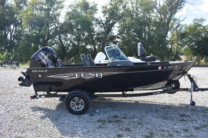 Slide: The Image of 2014 Lund 1650 Rebel XL Sport boat on trailer, parked outdoors. - 5