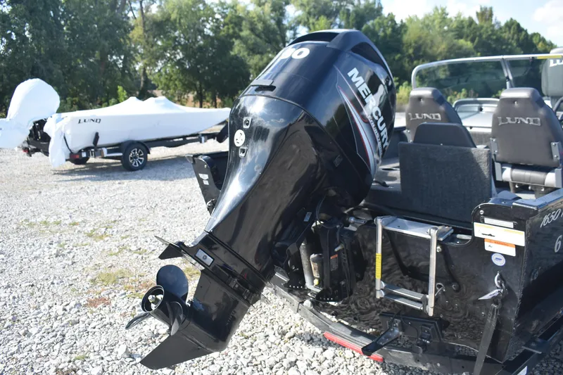 Slide: The Image of 2014 Lund 1650 Rebel XL Sport boat with Mercury outboard motor, parked on gravel. - 6