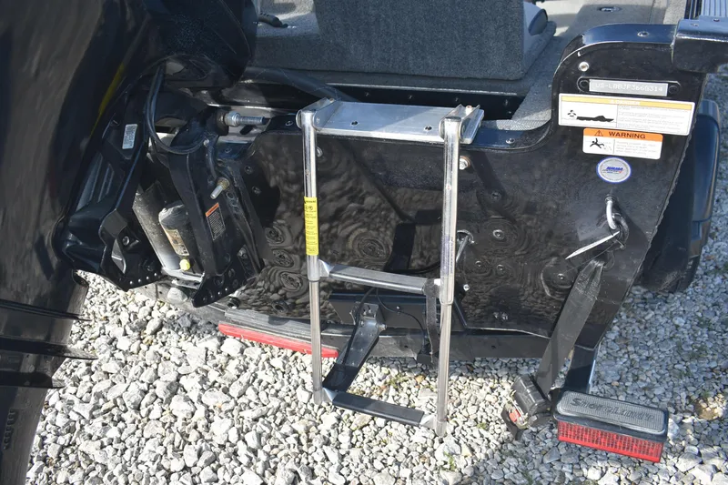 Slide: The Image of 2014 Lund 1650 Rebel XL Sport boat ladder and motor mount on gravel. - 7