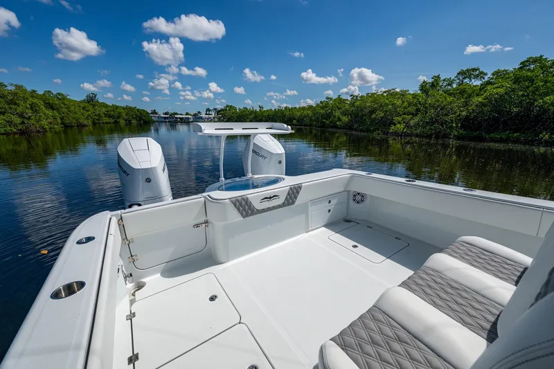 Slide: The Image of 2025 Invincible 33 Catamaran on serene waterway, featuring sleek design and dual outboard engines. - 11