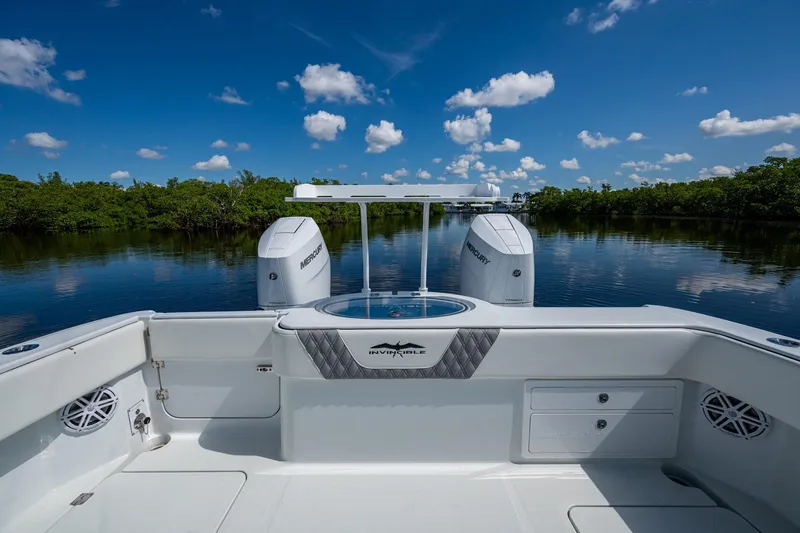 Slide: The Image of 2025 Invincible 33 Catamaran on serene water, featuring dual Mercury engines. - 13