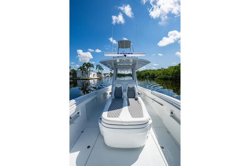 Slide: The Image of 2025 Invincible 33 Catamaran on calm water, showcasing sleek design and spacious deck. - 16