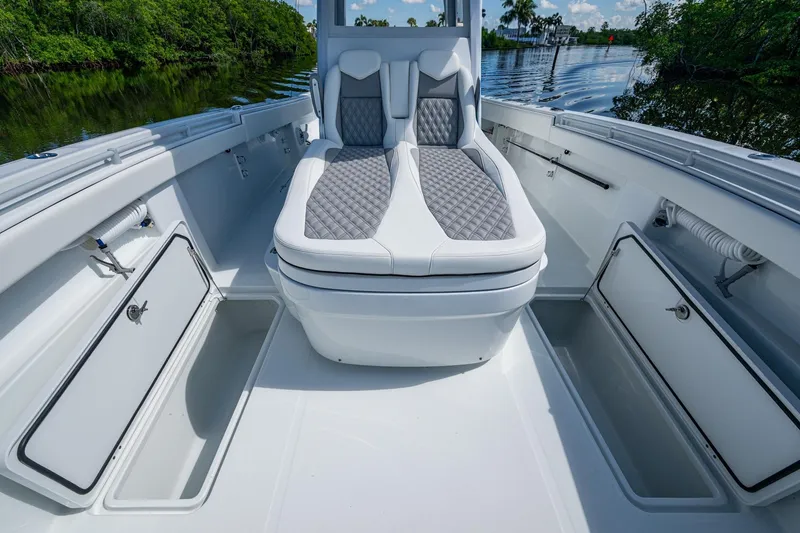Slide: The Image of 2025 Invincible 33 Catamaran interior with cushioned seating and storage compartments. - 17