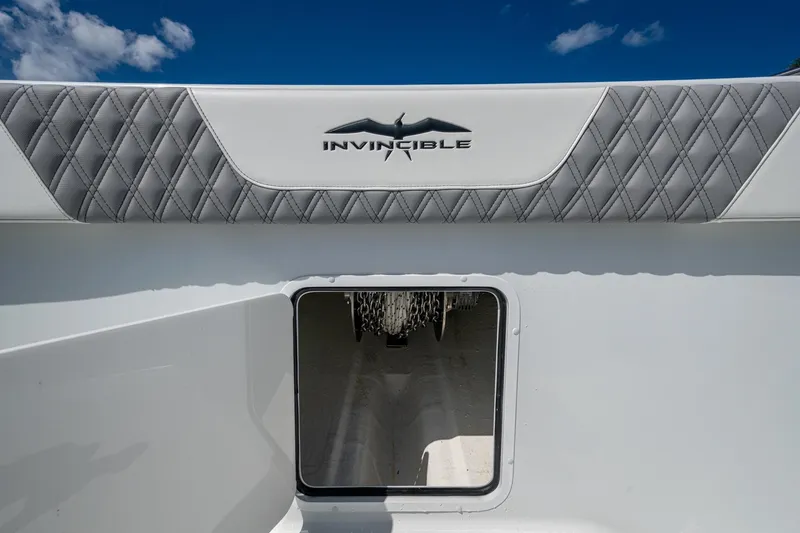 Slide: The Image of 2025 Invincible 33 Catamaran interior detail with logo and quilted upholstery. - 19