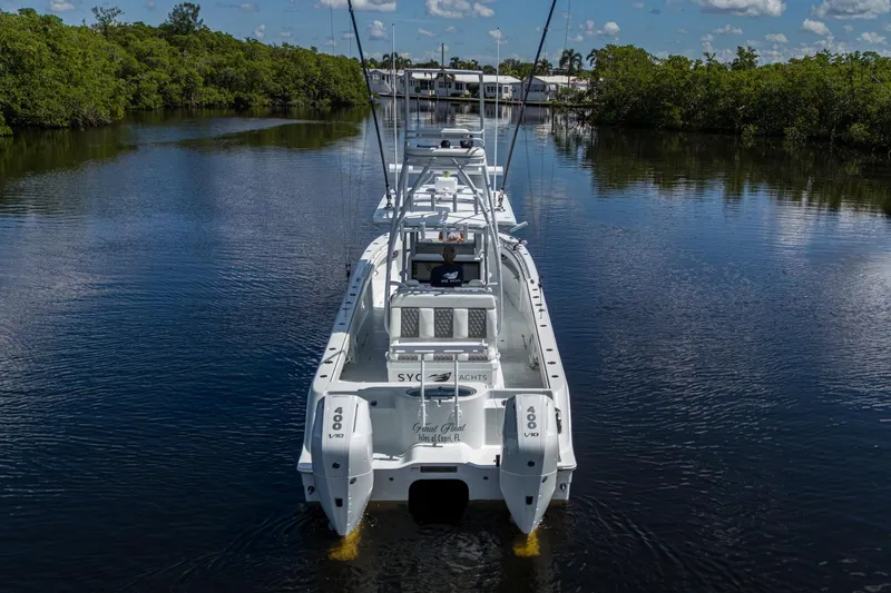 Slide: The Image of 2025 Invincible 33 Catamaran on calm water, surrounded by lush greenery. - 2