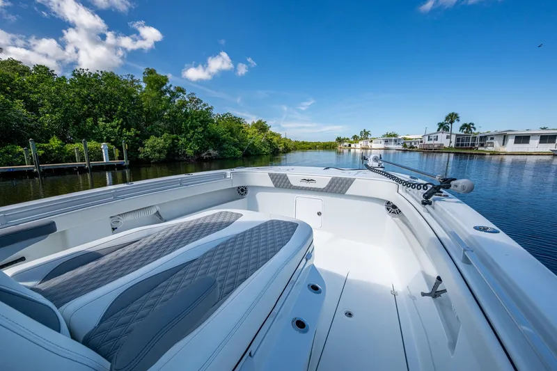 Slide: The Image of 2025 Invincible 33 Catamaran on a serene waterway, showcasing luxurious seating and sleek design. - 21