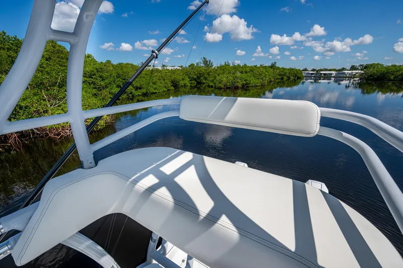 Slide: The Image of Invincible 33 Catamaran 2025 on serene waterway, surrounded by lush greenery and blue sky. - 28