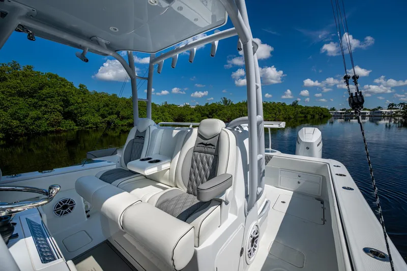 Slide: The Image of 2025 Invincible 33 Catamaran interior with luxurious seating, set against a serene water backdrop. - 7