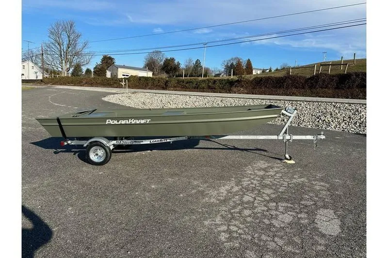Slide: The Image of 2024 Polar Kraft 1448 Jon Boat with trailer on paved surface, clear sky background. - 2